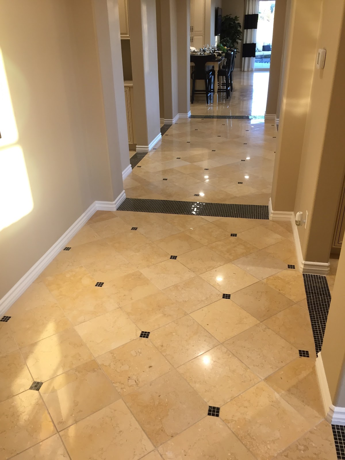 Polished travertine tile floor with mosaic accents installed by Kosty's Flooring