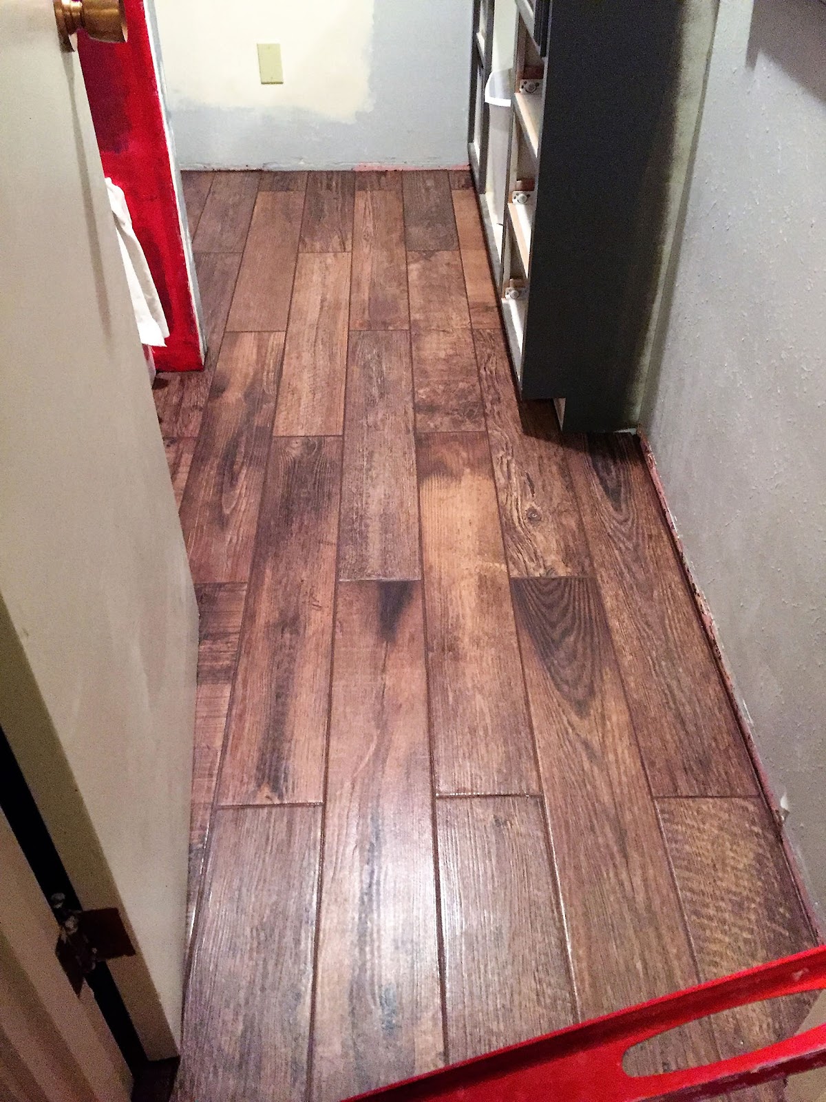 Wood-look tile plank flooring mid-installation