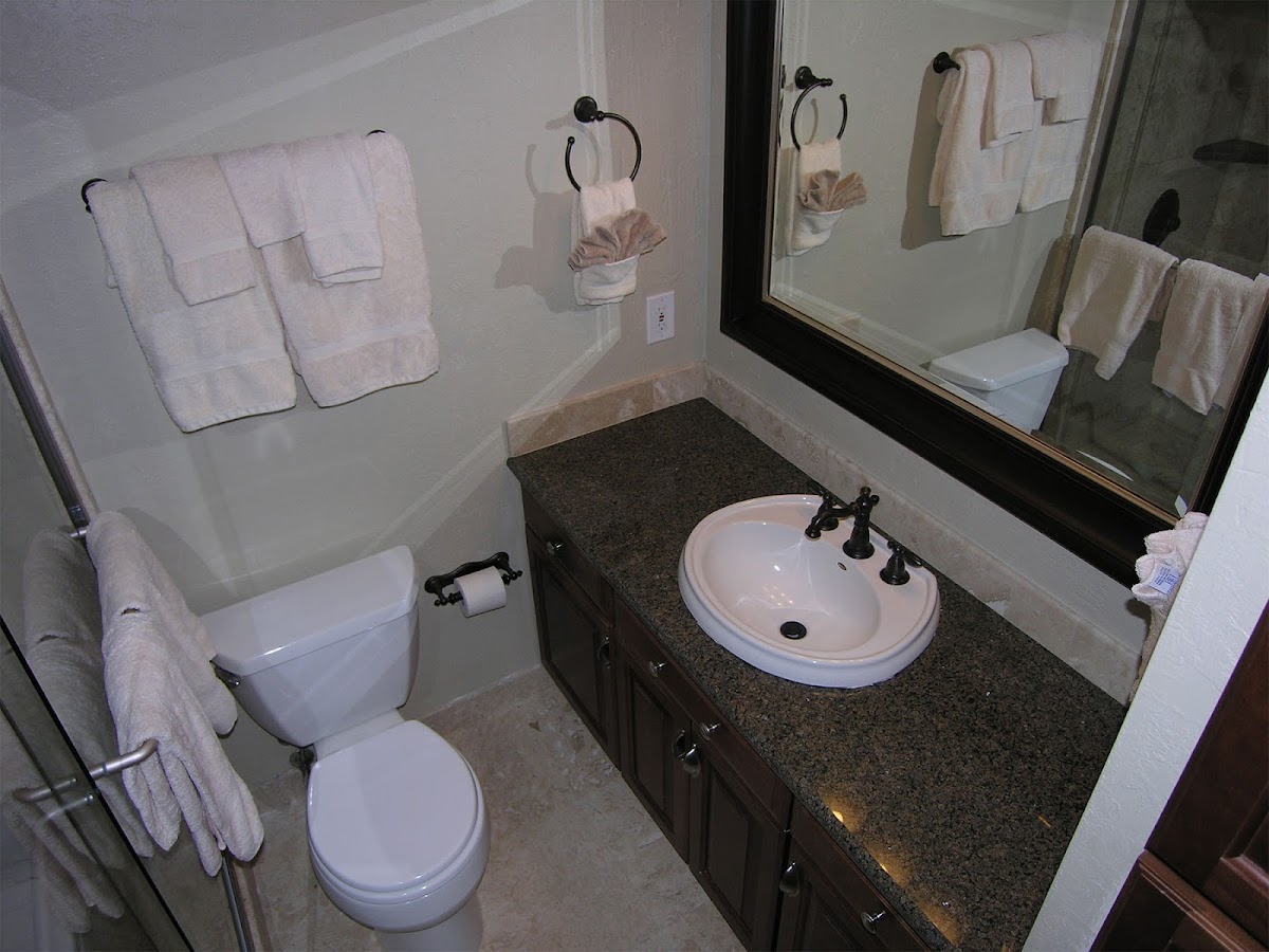 Remodeled bathroom with granite vanity and tile floor
